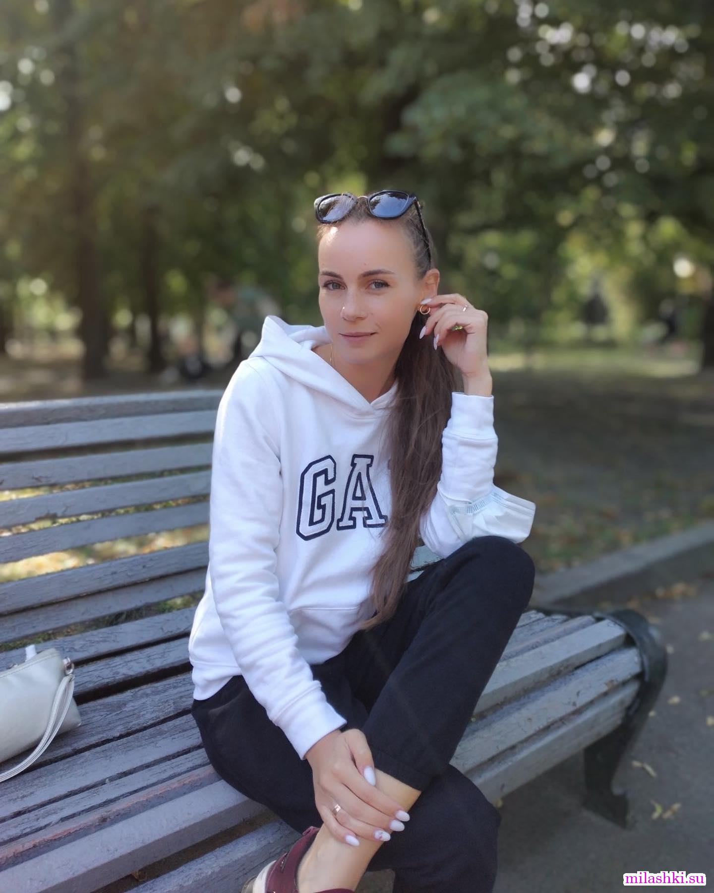 Длинноволосая девушка на скамейке в парке