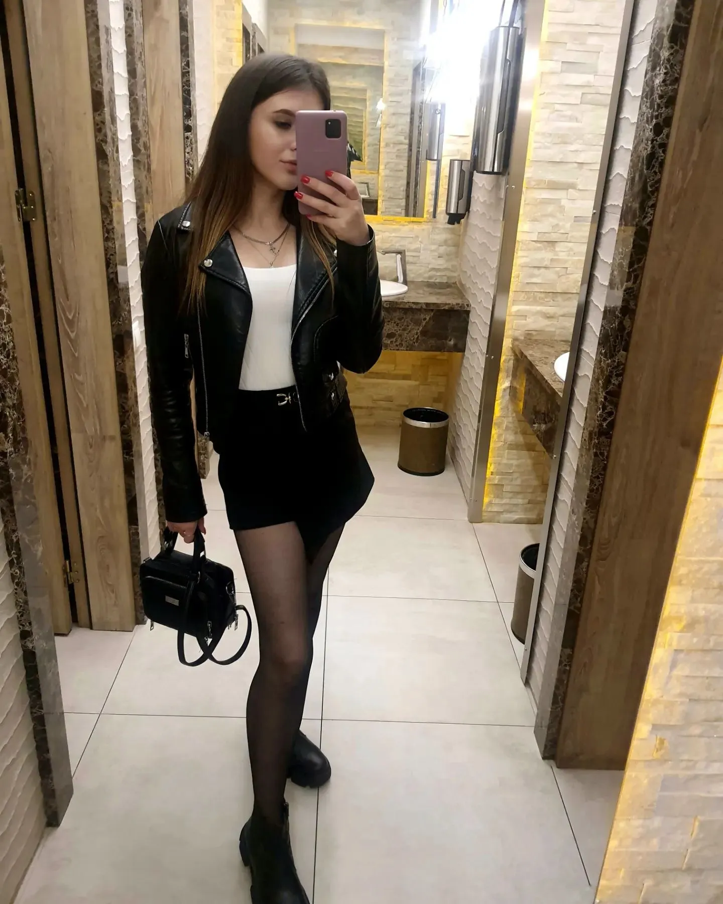 Девушка в миниюбке делает селфи в кафе